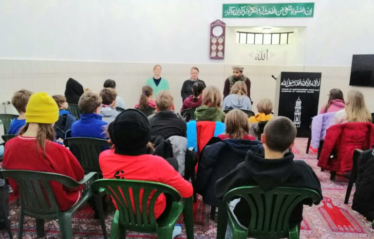 Schulklasse hört einem Vortrag in der Moschee zu